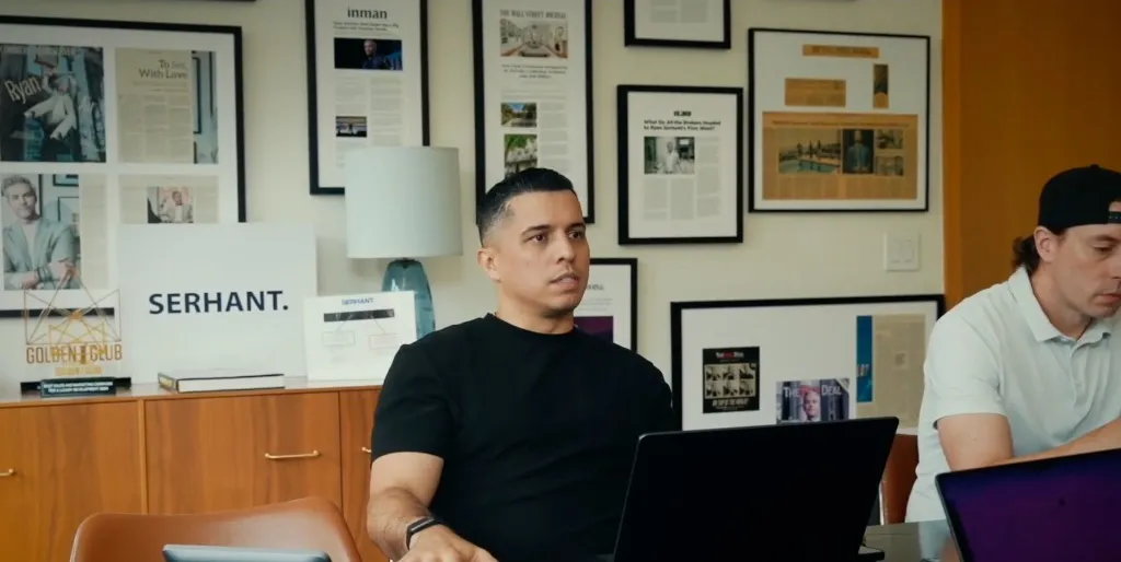 A SERHANT marketer at the conference table under a wall of press clippings