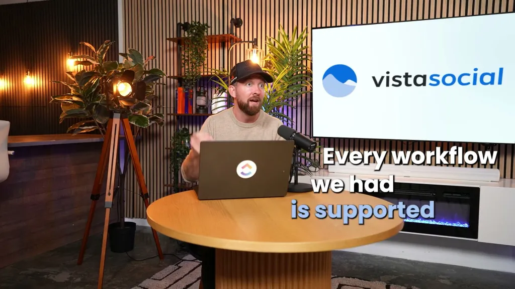 Chris Cunningham at a round table with a ClickUp laptop, in front of a Vista Social screen