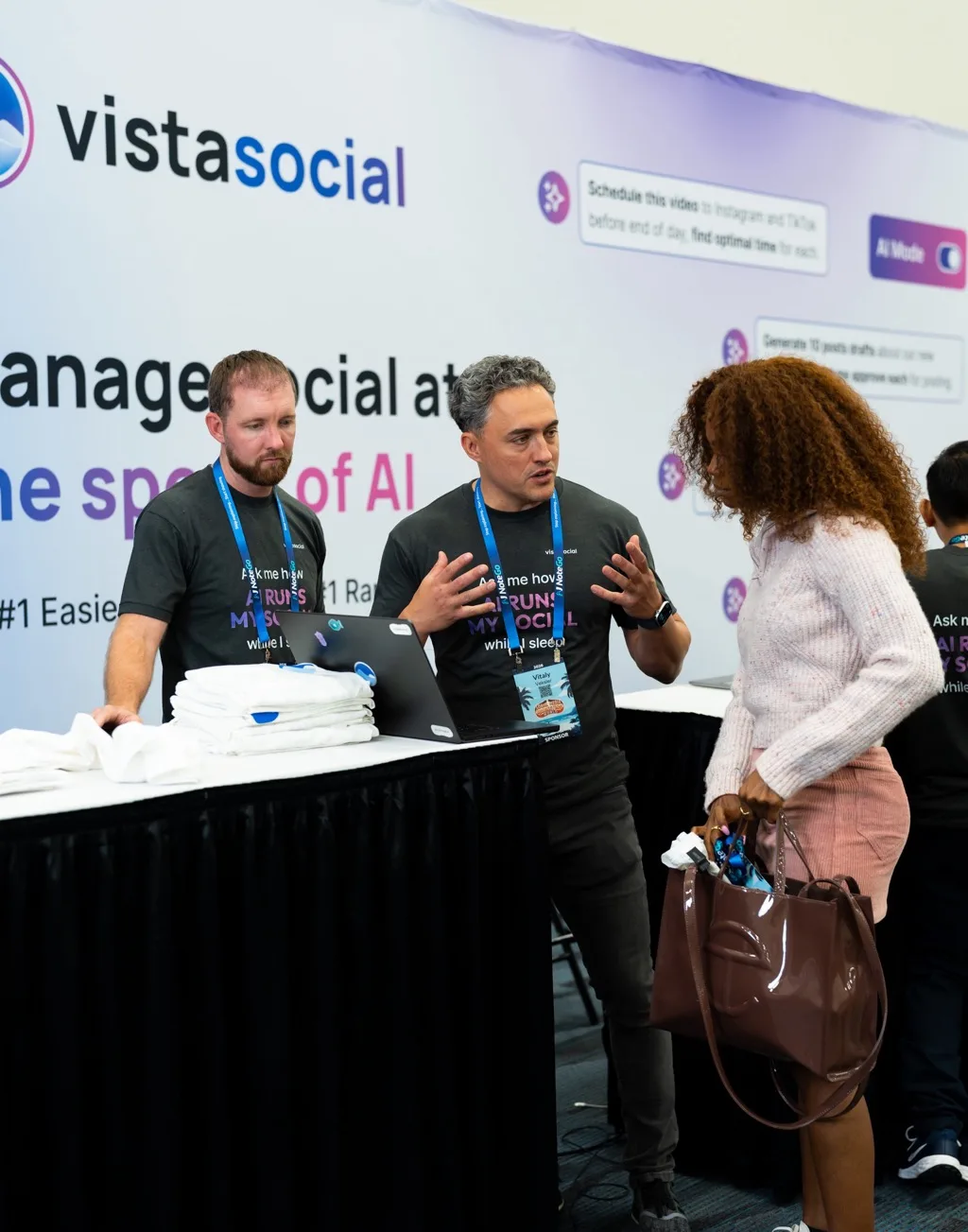 Vista Social team members walking a visitor through the product at the booth