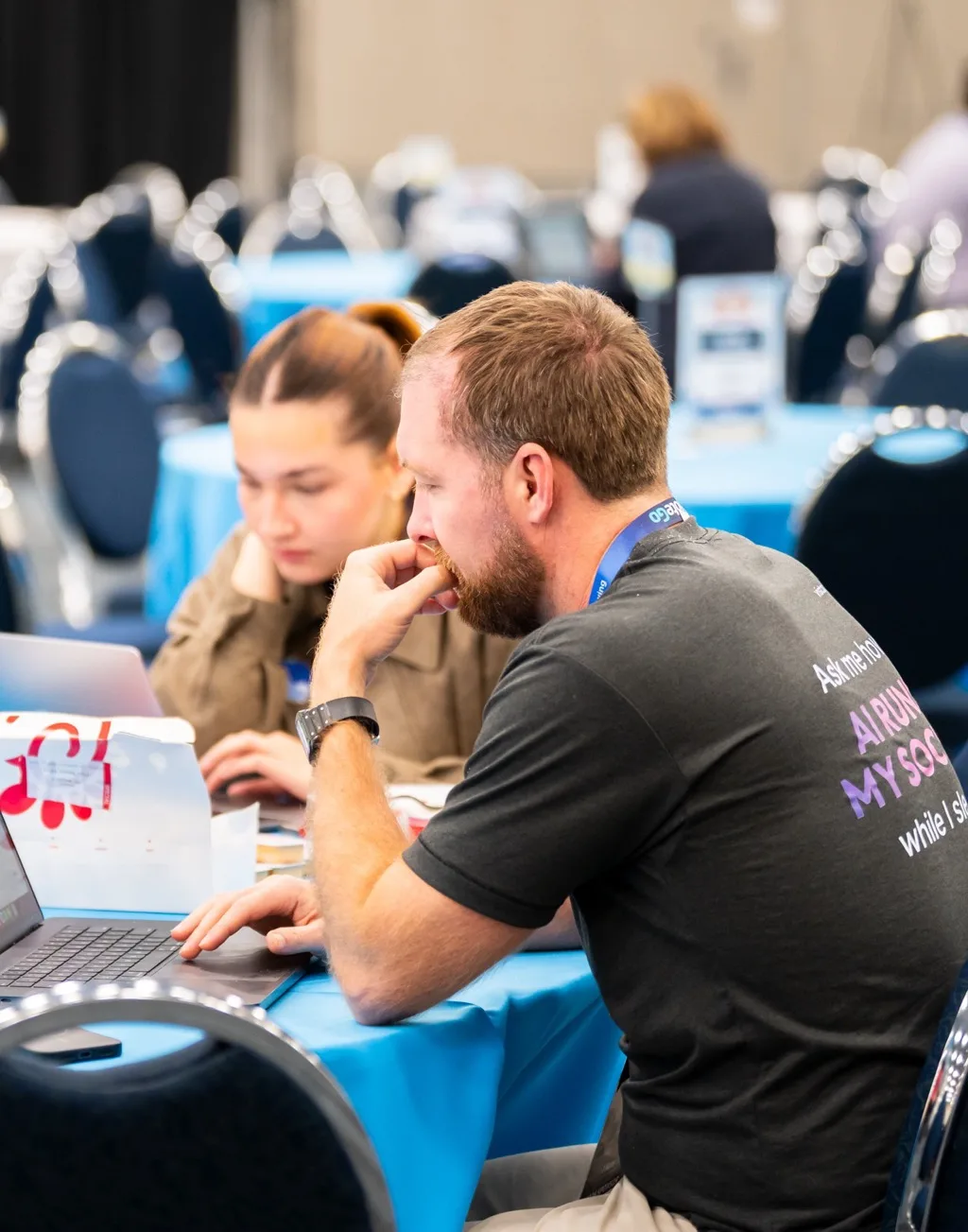 Two Vista Social team members working on laptops between sessions